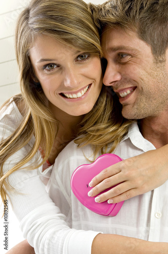 Photo: Portrait of a young woman embracing a mid adult man from behind Portrait of a young woman embracing a mid adult man from behind