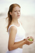 Young woman holding an apple, outdoors
