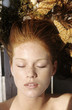 Young woman lying outdoors, sunbathing