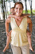 Mother giving daughter piggy back ride