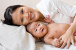 Smiling mother lying wih her baby
