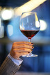 Female hand holding glass of red wine