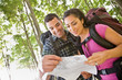 Couple in backpacks looking at map
