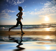 Woman running by the ocean at sunset
