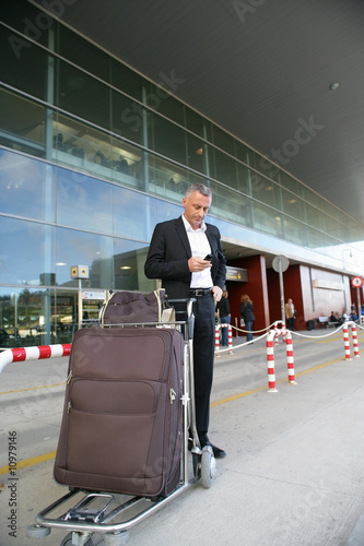 Homme d'affaires attendant un taxi à l'exterieur d'un aéroport Homme d'affaires attendant un taxi à l'exterieur d'un aéroport