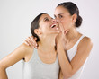 happy woman murmuring secret to her friend