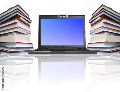 Computer among book piles