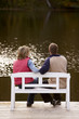 couple sitting on a bench at a lake in autumn