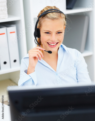 Happy young office worker wearing headset