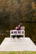 couple sitting on a bench at a lake in autumn