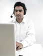 Photo: asian man working on his laptop wearing his headphones asian man working on his laptop wearing his headphones