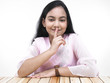 asian teenage girl of indian origin with finger on her lips