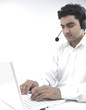 Photo: asian man working on his laptop wearing his headphones asian man working on his laptop wearing his headphones