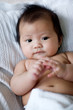Baby lying in bed, hands together Baby lying in bed, hands together