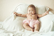 Baby sitting up in bed, smiling. Vintage tones.