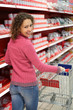 Woman in shop is standing half-turned, smiles