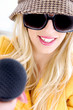 front view of smiling woman in sunglasses holding mic
