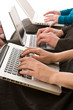 Business people using laptops to make notes