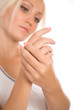 Young woman applying cream to hands