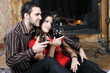 Happy couple in love enjoying wine near fireplace Happy couple in love enjoying wine near fireplace