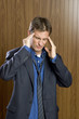 Businessman experiencing a headache rubbing his temples