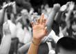 hand raised among others hands in background hand raised among others hands in background
