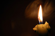 Smoke and candle flame burning in the darkness
