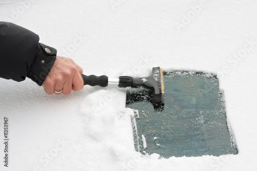 Hand mit einem Eiskratzer Hand mit einem Eiskratzer