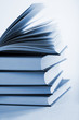 pile of books with one book open