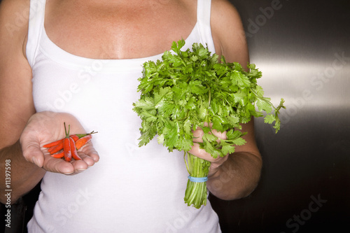 Photo: Close up of woman holding peppers and cilantro Close up of woman holding peppers and cilantro