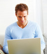 Young man working on laptop computer at home