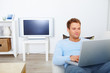 Modern guy using laptop in living room