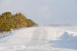 A bad weather on rural road.  Glaze ice,  snowdrift.