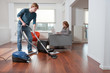 Man vacuum cleaning woman working