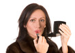 Photo: Beautiful woman applying red lipstick. White background Beautiful woman applying red lipstick. White background