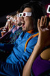 Audience in cinema wearing 3D glasses, making faces, close-up