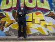 Businessman posing in front of graffiti wall