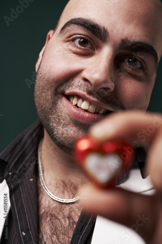 Photo: young man presenting heart in hand young man presenting heart in hand