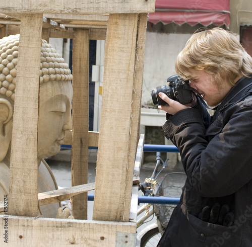 Photo: Photographer taking a photo of a Buddha in a box Photographer taking a photo of a Buddha in a box