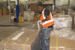 Photo: Warehouse worker hand sealing pallet with plastic Warehouse worker hand sealing pallet with plastic