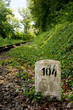 Milestone next to railroad tracks in forest Milestone next to railroad tracks in forest