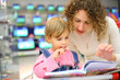 Mother and daughter looks in book in shop