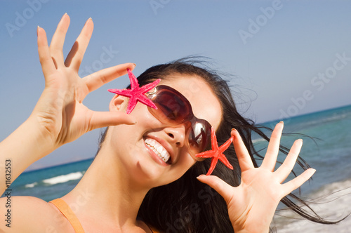 Photo: oung beautiful woman holding two starfish at the seaside oung beautiful woman holding two starfish at the seaside
