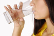 Beautiful young girl drinks water from glass