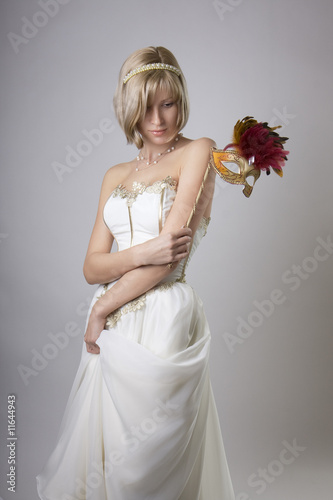 Photo: Girl in evening dress with a carnival mask Girl in evening dress with a carnival mask
