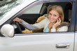 Foto: Young woman in her car while on the cell phone Young woman in her car while on the cell phone