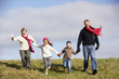 Grandparents And Grandchildren Running In The Park