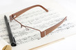 glasses, ball pen and old musical notes on white background