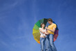 Happy couple under colorful umbrella