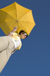 Glamour woman under yellow umbrella from low point of view Glamour woman under yellow umbrella from low point of view